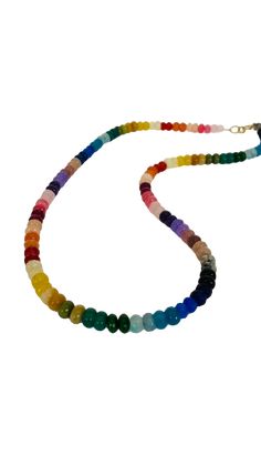 This necklace is a vibrant and eye-catching piece of jewelry that features colorful rondelle beads in a rainbow spectrum of shades. The necklace measures approximately 20 to 21 inches in length and can be adjusted to a shorter length, allowing for a customized fit. The rondelle beads are small, cylindrical-shaped beads that have been faceted to catch and reflect light, enhancing their brilliance and adding a touch of sparkle to the necklace. The beads are arranged in a rainbow pattern, with each color seamlessly transitioning into the next, creating a visually captivating and joyful design. The rainbow shades of the rondelle beads may include vibrant hues such as red, orange, yellow, green, blue, indigo, and violet. This colorful arrangement adds a playful and lively element to the necklac Multicolor Single Strand Rondelle Beaded Necklaces, Multicolor Rondelle Beaded Necklaces Single Strand, Multicolor Rondelle Beaded Necklace Single Strand, Adjustable Rainbow Single Strand Beads, Adjustable Single Strand Rainbow Beads, Adjustable Rainbow Polished Beads Necklace, Adjustable Rainbow Necklaces With Polished Beads, Rainbow Rondelle Gemstone Bead Necklaces, Rainbow Rondelle Gemstone Beads Necklace