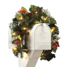 a white mailbox decorated with christmas wreath and lights