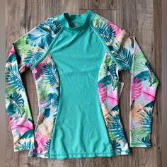 New With Tags Pipeline Blue Pink Orange Green Size Medium Long Sleeved Rashguard That Has A Floral Design On The Sleeves And Sides Upf 50+ Ultraviolet Protection Factor Wearable Sunblock From A Pet And Smoke Free Home *Bundle With Another Item And Get 10% Off *If You Are New To Poshmark You Can Sign Up With This Code Creativekat504 Or Use The Link Below And Receive $10 With Poshmark Https://Posh.Mk/Jvdrouxohgb Questions? Leave A Comment Below! Light Blue Long Sleeve Tops For Beach Season, Blue Tropical Print Long Sleeve Top, Blue Long Sleeve Top With Tropical Print, Blue Long Sleeve Tops With Tropical Print, Blue Floral Print Long Sleeve Swimwear, Blue Tropical Print Tops For Beachwear, Multicolor Stretch Beachwear Tops, Fitted Tropical Blue Top, Fitted Blue Tropical Top