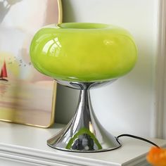 a green lamp sitting on top of a white shelf