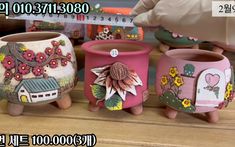 three flower pots sitting on top of a wooden table