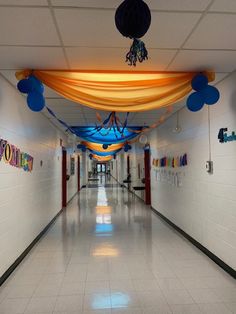 an empty hallway with balloons and streamers on the ceiling, decorated for a birthday party