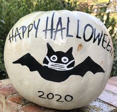 a happy halloween pumpkin with a bat painted on it