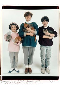 three children are holding cats and posing for a photo in front of a white background