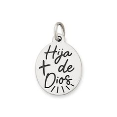 a silver charm with the words'hija de dios'in black ink