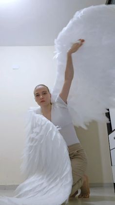 a woman with white wings is posing for the camera