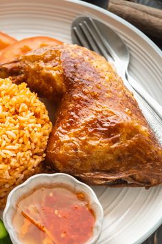 a white plate topped with meat, rice and vegetables