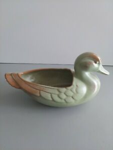 a ceramic duck shaped bowl sitting on top of a white countertop next to a wall