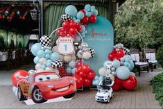 cars and balloons are on display at an amusement park