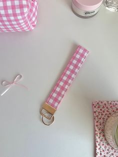 a pink and white checkered belt next to some other items on a counter top