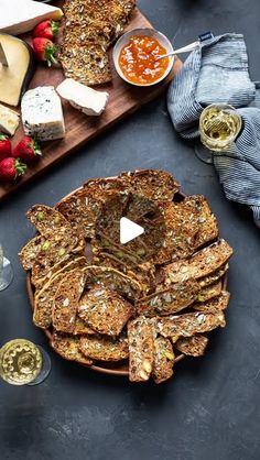 an assortment of cheeses and crackers on a wooden platter