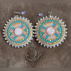 the earrings are made with beading and beads on top of a dime penny coin