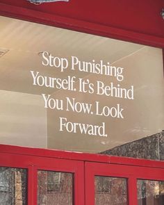 a sign on the side of a building that says stop pushing yourself it's behind you now look forward