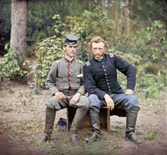 two men sitting on a bench in the woods