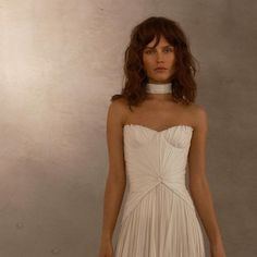 a woman in a white dress with a choker on her neck is posing for the camera