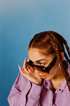 a woman wearing sunglasses covers her face with her hands