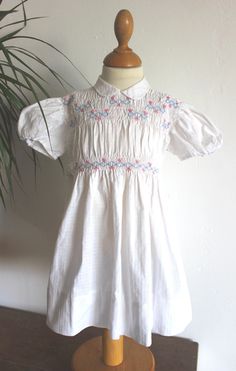 "FRENCH VINTAGE 50's, stunning white smocked dress, textured cotton fabric, hand embroideries, buttoned at the back ( mother of pearl buttons ), belt to tie.  Estimated size 18/24 months Length 18,5\" - Shoulders 9,6\" New old stock ( washed once ) I always refund overcharged shipping from 1 Euros overpaid ! Thank you for your visit" White Short Sleeve Smocked Dress For Daywear, White Smocked Dress With Short Sleeves For Daywear, Fitted Smock Dress For Daywear, Fitted Smocked Dress With Floral Embroidery For Daywear, White Smocked Short Sleeve Dress For Daywear, White Short Sleeve Smocked Day Dress, Cotton Smocked Short Sleeve Dress For Daywear, Fitted Vintage Smocked Dress For Summer, Cotton Short Sleeve Smocked Dress For Daywear