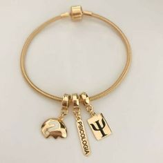 a gold bracelet with two charms on it