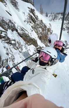 two people on skis going up a snowy mountain