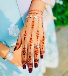 a woman's hand with henna tattoos on it