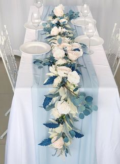 a long table with white and blue flowers on it