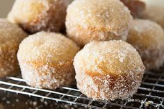 some sugared donuts are sitting on a cooling rack