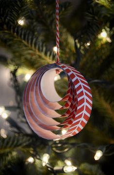 a red and white ornament hanging from a christmas tree