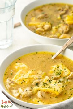 two bowls of chicken and dumpling soup with a spoon