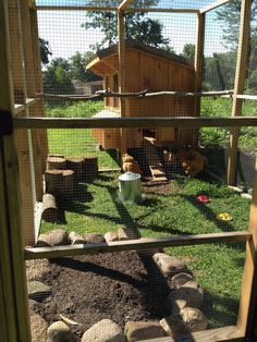 an outdoor chicken coop with rocks and grass