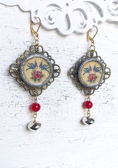 Sailor Jerry Tattoo Blue Bird Sparrow Red Rose Flower Bohemian Rockabilly Clay Statement Earrings. Blue bird and red rose Sailor Jerry tattoo silver glitter polymer clay resin photo discs on antique brass filigree with pink and silver glass beads. These rockabilly statement earrings are 3.5 inches long and 1.75 inches wide. Gold plated lever back ear hooks. Thank you so much for stopping by Avocado Green Designs today! Blue Bird Tattoo, Sparrow Earrings, Sailor Jerry Tattoo, Red Rose Earrings, Jerry Tattoo, Bluebird Tattoo, Vogel Tattoo, Assemblage Earrings, Sailor Jerry Tattoos