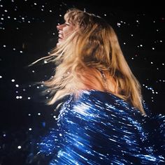 a woman with long hair standing in the dark