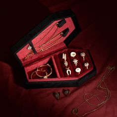 an open red velvet box with jewelry in it