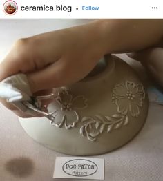 a person is using scissors to decorate a vase