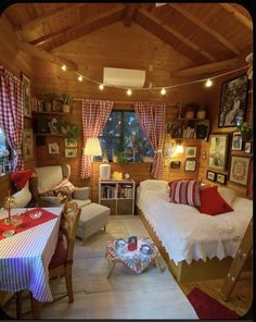 a living room filled with furniture and pictures on the wall next to a table covered in red and white checkered cloths