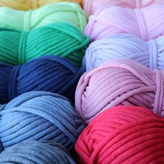 several balls of yarn are lined up in different colors and sizes, all on top of each other