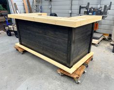 a large wooden box sitting on top of pallets in a garage next to a building