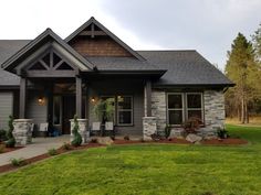 a house that is in the grass and has some plants on the front lawn outside