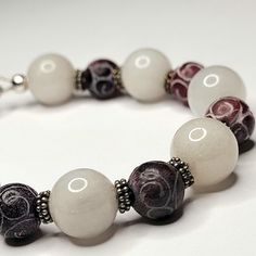 This bracelet is for a smaller wrist at 6.5 inches. This is the perfect pattern of snowy white quartz beads, dark, rich burgundy Dzi beads and little Bali sterling silver spacer beads. The Dzi (pronounced zee) beads are dyed agate etched with a unique pattern of swirls.  In several Asian cultures, including that of Tibet, the Dzi bead is considered to provide positive spiritual benefit to the wearer. I know you will look positively beautiful wearing this bracelet! If you like this piece please c White Natural Stones Beads For Gift, White Natural Stones Beads As Gift, White Beaded Crystal Bracelet For Healing, White Beaded Crystal Healing Bracelet, White Crystal Bracelet With Large Beads As Gift, White Crystal Bracelet With Large Beads For Gift, White Natural Stones Beads For Healing, White Spiritual Stretch Bracelet With Large Beads, White Natural Stones Beaded Bracelet