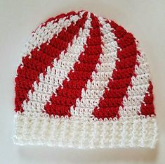 a crocheted red and white hat sitting on top of a table