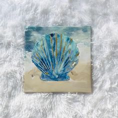 a painting of a blue shell on a white blanket