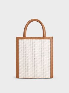 Our woven bag made in a chocolate-beige combination will add a refreshing touch to all your summer looks this season. Contrasted by a beautiful brown trim and a texturally rich body, this bag is versatile, chic and functional. The compact-sized interior ensures ample space for all your daily essentials, while the magnetic closure keeps them secure. On your next resort getaway, we recommend styling it with a floral dress and straw hat. Complete the look with a tie-around platform sandals. Trapeze Bag, Slouchy Tote, Chain Strap Bag, Brown Trim, Size Chart For Kids, Charts For Kids, Charles Keith, Orange Bag, Bag Light