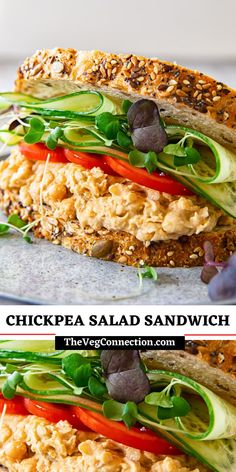 chicken salad sandwich with lettuce, tomato and cucumber on it in the middle