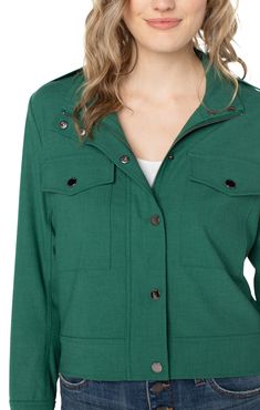 Liverpool Los Angeles's Utility Crop Jacket offers minimalism with on-trend appeal. Crafted from a soft and stretchy twill fabric, this piece provides an optimal blend of feminine charm and edgy appeal for versatile styling. Final Sale - No returns or exchanges. Color - Serpentine; Bright green. Collared. Double front patch pockets. Button and zip front closure. Snap closure at wrists. Cropped style. Fabric - 47% Polyester. 44%Viscose. 6%Elastane. 3% Other Fiber. Care-Turn inside out. Machine as Stretch Button-up Fall Outerwear, Stretch Outerwear With Pockets For Everyday, Stretch Button-up Outerwear For Fall, Versatile Stretch Outerwear For Work, Stretch Outerwear With Button Closure For Work, Classic Stretch Outerwear For Layering, Stretch Button-up Outerwear For Work, Modern Stretch Outerwear For Work, Versatile Fall Utility Jacket