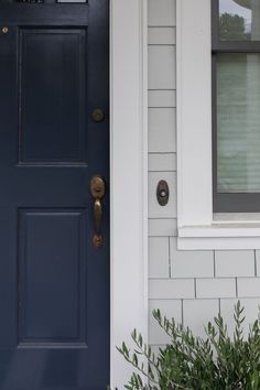 a blue front door with white trim on a house