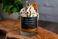 a glass cup filled with whipped caramel pretzel ice cream on top of a wooden table