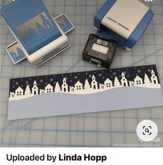 some type of stamping tape with buildings and snowflakes on it, along with two rubber stamps