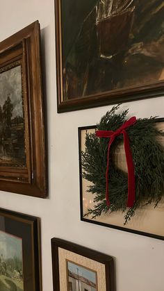 the wall is decorated with pictures and wreaths