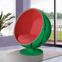 a green and red ball chair sitting on top of a white rug next to a window