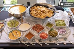 a buffet table filled with different types of food and condiments, including guacamole