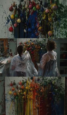 two people sitting in front of an art work with flowers and paint splattered on the walls